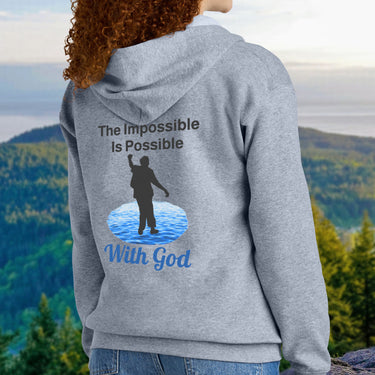 Gildan youth zip-up hoodie with “Impossible Teen” design featuring a teen walking on water and uplifting message, Christian apparel made from soft preshrunk fleece, perfect for cold weather and spiritual encouragement, teen in gray hoodie